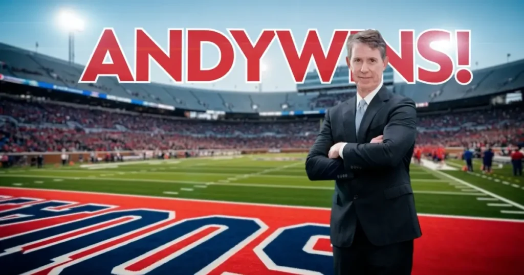 A man in a suit stands on a football field with a stadium in the background. Large red text above him reads "ANDY WINS!.