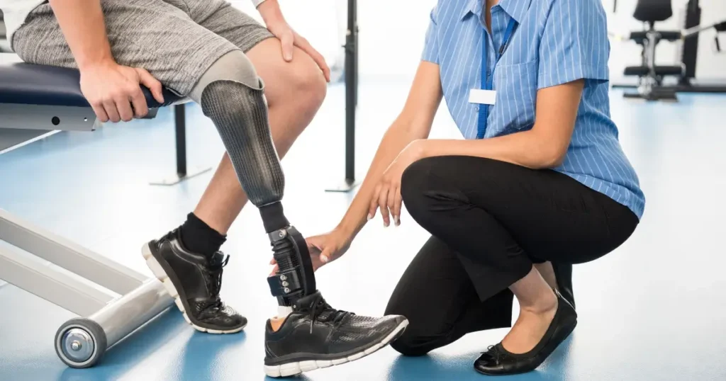 A healthcare professional examines the prosthetic leg of a seated patient in a medical facility.