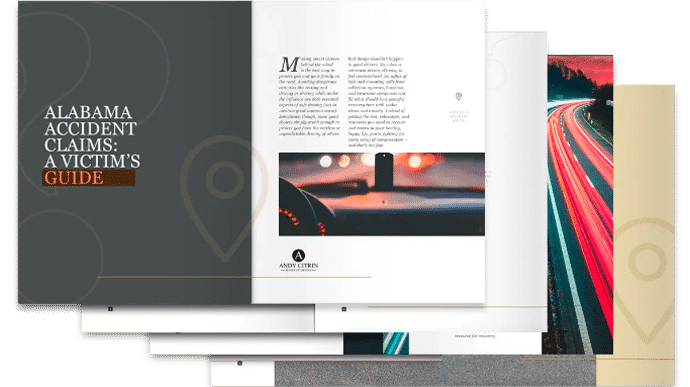 A stack of open brochures with the top one titled "Alabama Accident Claims: A Victim's Guide," showing text and an image of a steering wheel.