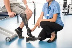 young man with prosthetic leg with physical therapist
