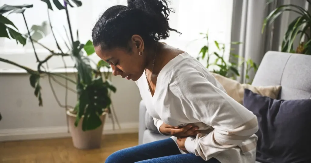 young black woman showing stomach pain