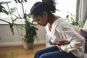 young black woman showing stomach pain
