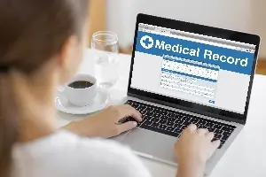 woman looking at medical records on laptop